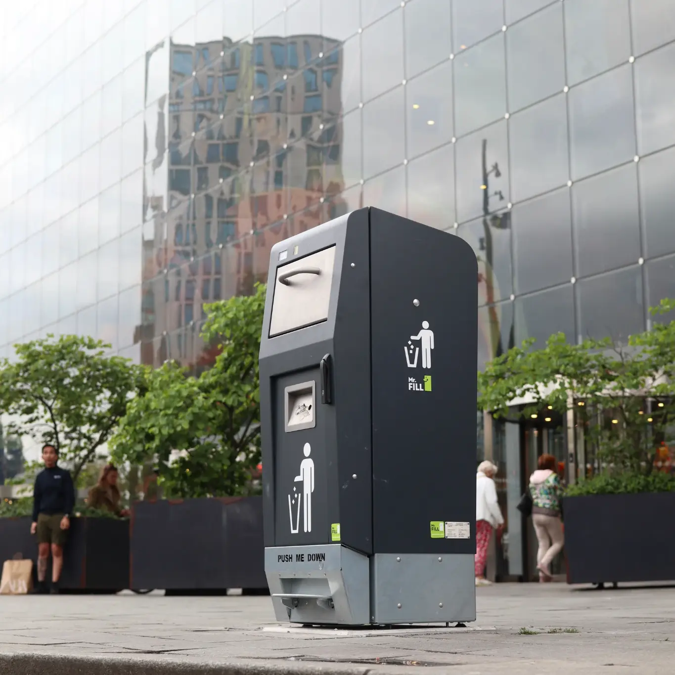 Von Interzero vertriebenes Produkt: Mr. Fill-Abfallbehälter - Stadtischer Wertstoffbehalter vor Glasbuerogebaeude, Interzero, 2026